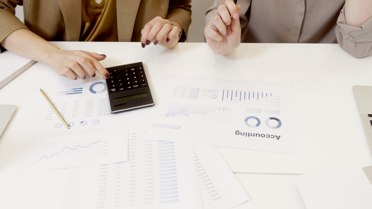 Crafting Captivating Headlines: Your awesome post title goes here Two professionals analyzing financial documents with a calculator.